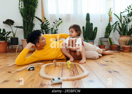Mother lying down by son playing at home Stock Photo