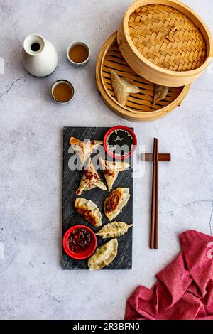 Steamed prawn dumplings and chicken pot stickers with chilli oil Stock Photo