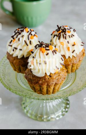 Spiced carrot and nut Autumn cupcakes, decorated with cream cheese frosting and sprinkles Stock Photo