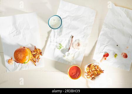 Burgers eaten on table with papers left Stock Photo