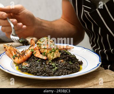 Squid ink risotto with seafood Stock Photo