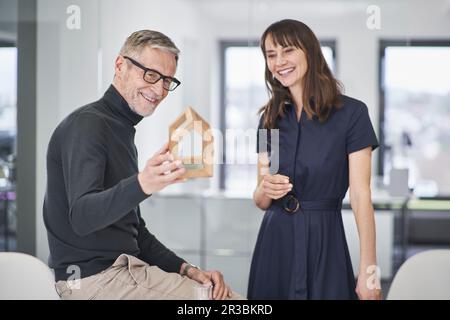 Two smiling architects looking at model house in office Stock Photo