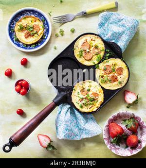 Mini omelettes with sausages in omelet pan Stock Photo
