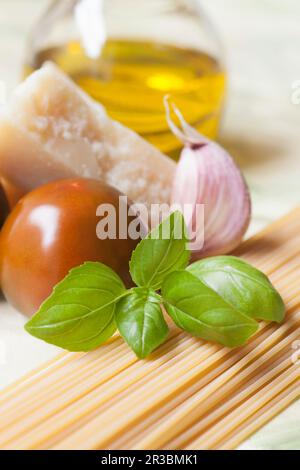An arrangement of spaghetti, garlic, tomato, Parmesan cheese and basil Stock Photo