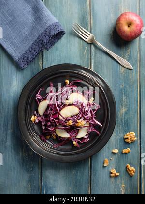 Red cabbage salad with apples wedges and piece of nuts Stock Photo