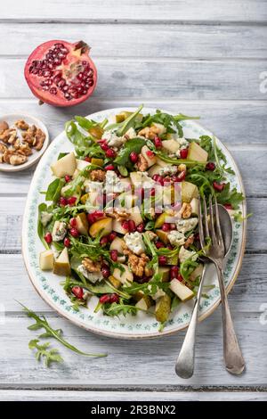 Pear, salad with gorgonzola cheese, pomagranate seeds, rocket, walnuts, walnuts and half of pomegranate Stock Photo