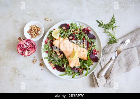 Roast salmon on rocket salad with beetroot and pomegranate seeds Stock Photo