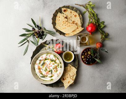 Iranian labneh with taftan bread and pomegranate Stock Photo