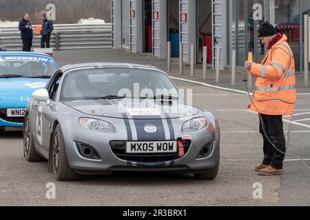 Nigel and Catherine Brain in their Mazda MX5 with the control point marshal  during the 2023 Snetterton Stage Rally, Norfolk, UK. Stock Photo