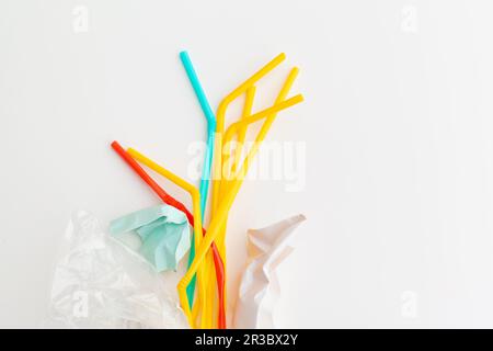 Plastic waste danger ecology concept with garbage and colorful single use straws, cutlery cups, bottles on white background Stock Photo