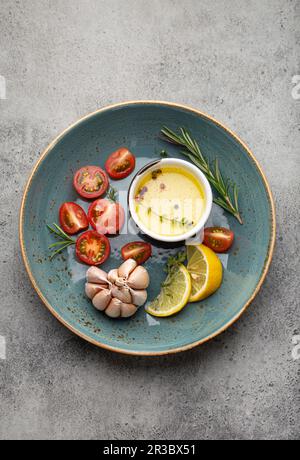 Vegetables, herbs, spices and olive oil on blue ceramic plate Stock Photo