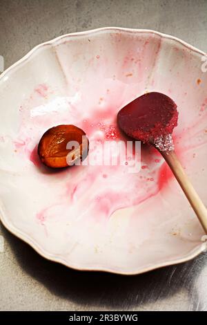 Making plum jam: used wooden spoon on a plate Stock Photo