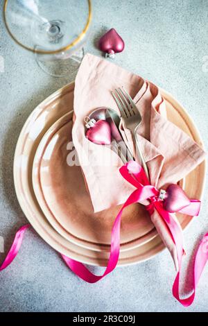 Christmas table setting with dust pink plates and cutlery in served setting for Christmas dinner Stock Photo