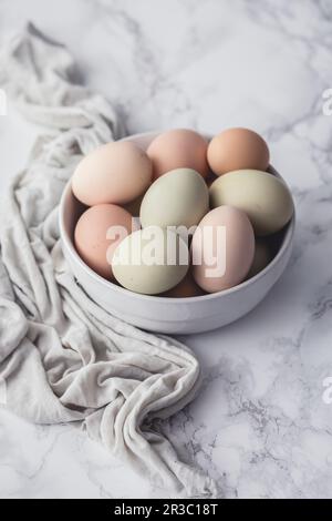 Fresh eggs in a bowl, on a marble surface Stock Photo