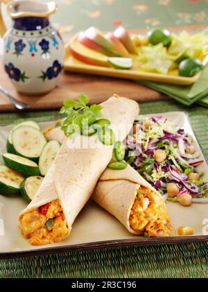 Chicken and cheese enchiladas with sauteed zucchini squash and cabbage slaw Stock Photo