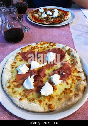 Two different pizzas on a restaurant table Stock Photo
