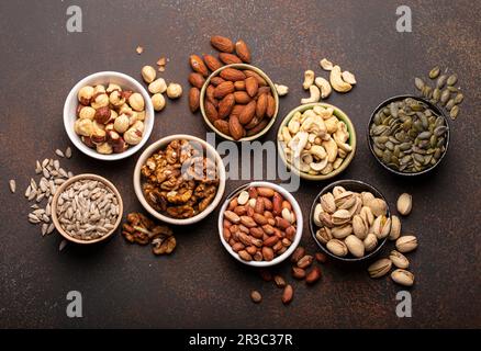Assorted nuts and various seeds in bowls Stock Photo