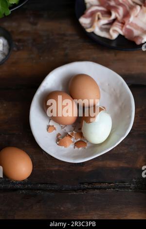 Hard-boiled eggs, one partially peeled Stock Photo