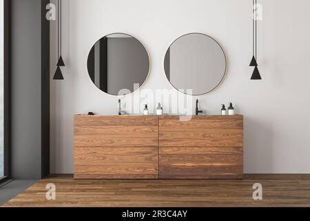Corner of modern bathroom with white and gray walls, wooden floor, double sink and two round mirrors. Window with blurry view. 3d rendering Stock Photo