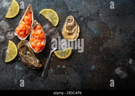 Salmon tartare raw chopped in cubes served in oyster shells Stock Photo