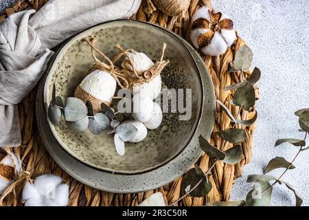 Easter festive table setting with tiny eggs and tableware on stone background Stock Photo