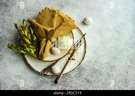 Easter festive table setting with tiny eggs and tableware on stone background Stock Photo
