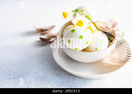 Easter frame concept with daffodils and eggs on concrete background Stock Photo