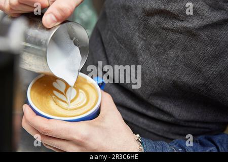 Latte art being poured on a coffee Stock Photo