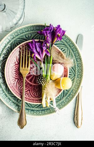 Spring Easter floral table setting decorated with wild purple iris flowers on concrete table Stock Photo