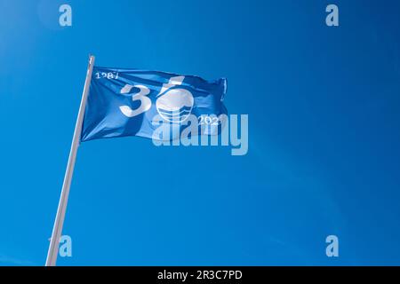 Waving blue flag in Albir beach, Alicante province, Spain. The Blue Flag is an international award for beaches and marinas Stock Photo