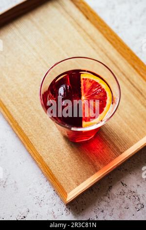 Negroni with a slice of Blood Orange on a wooden tray Stock Photo