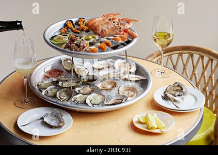 Seafood sharing plates with white wine being poured Stock Photo