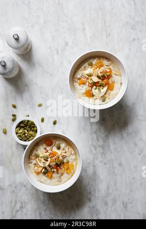 Porridge with apricots, flaked almonds and pumpkin seeds Stock Photo