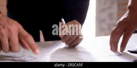 Closeup hands young caucasian architect woman looking laptop and working drawing blueprint for planning building house, engineer thinking and sketchin Stock Photo
