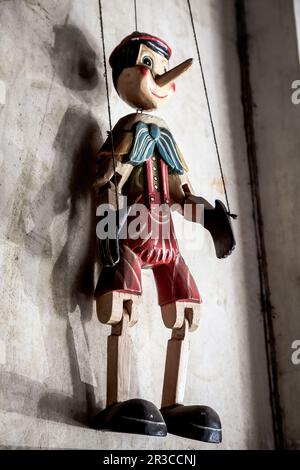 Wooden String Puppet Boy hanging on a wall Stock Photo