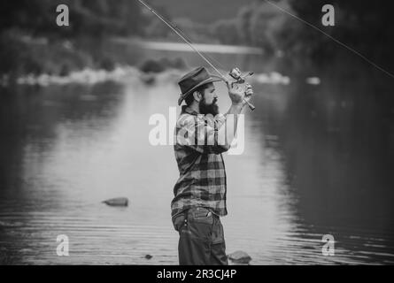 Angler catches fish for spinning. Pulls the fishing line with a spinning  Stock Photo - Alamy