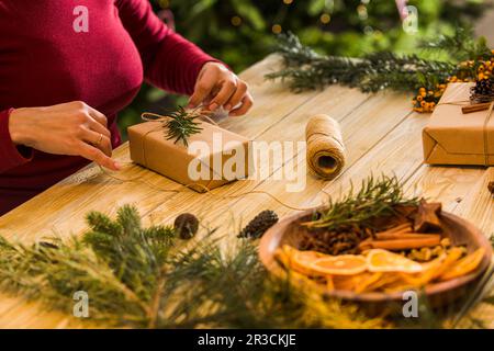 Process of packing Christmas gift boxes with natural materials Stock Photo