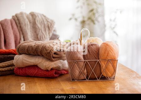 Stylish metal basket with balls of yarn Stock Photo