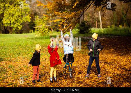 The kids like to play with leaves in the autumn season Stock Photo