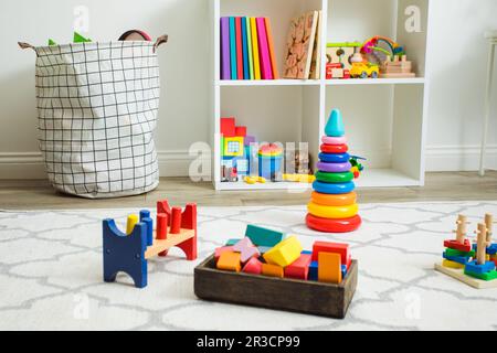 Colorful toys on white carpet in children room Stock Photo