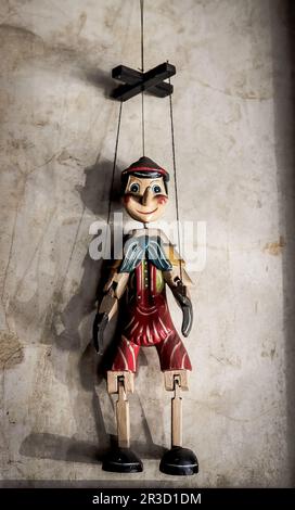 Wooden String Puppet Boy hanging on a wall Stock Photo