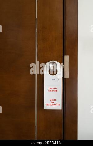 the sign with the inscription in English and Bulgarian ' do not disturb ' hanging on the door of a hotel room Stock Photo