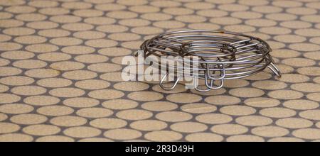 Metal trivets stacked on a dining table. Stock Photo