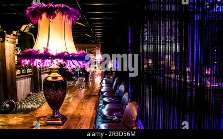 Pink table lamp on old school traditional wooden bar counter Stock Photo