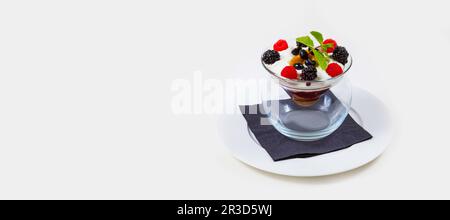 Berry and icecream dessert in a clear glass bowl on a white plate on a white background Stock Photo