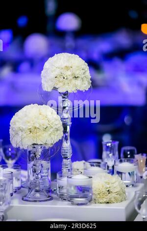 Decor with candles and white flowers for a large corporate party event or Gala Dinner Stock Photo