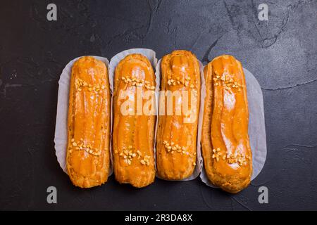Sweet and delicious eclairs on black background Stock Photo