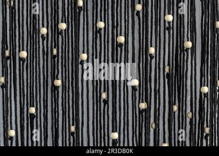 Hand woven black macrame with white beads hanging on wall Stock Photo -  Alamy