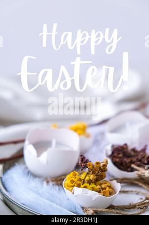 HAPPY EASTER lettering greeting card text. Trendy Easter decorations. Cracked organic eggs with dry grass and dry flowers on pla Stock Photo