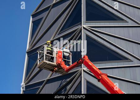 Window cleaning crew on articulating boom lift at Rotermanni Quarter in Tallinn, Estonia Stock Photo